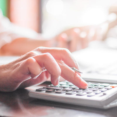 Close up Of woman's hand using calculator to check her insurance premium